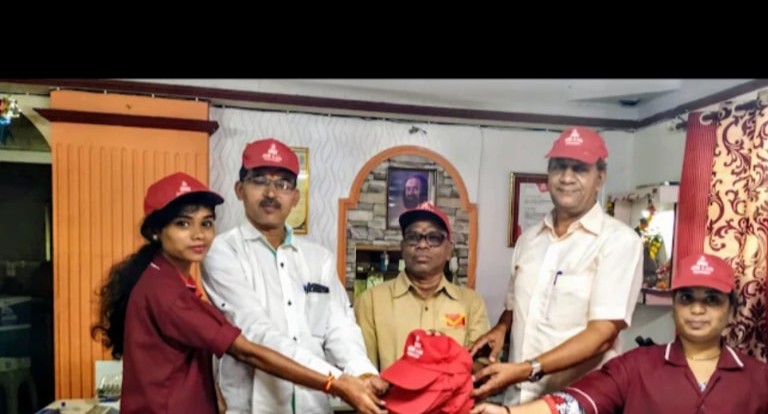 Om Lab Team Members In Red Service Caps At A Community Event
